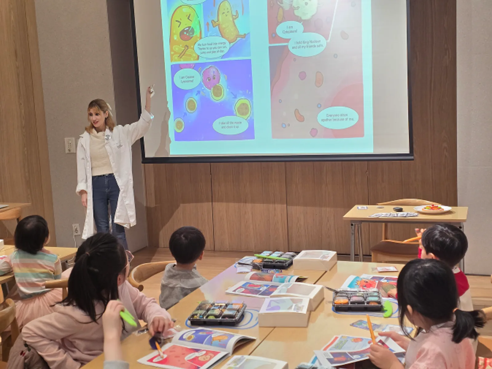 An instructor shows picture materials and goes over a science concept with children in a Food & Science class