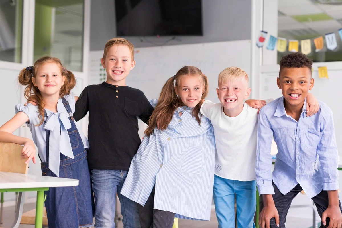 Children smiling with their arms around each other