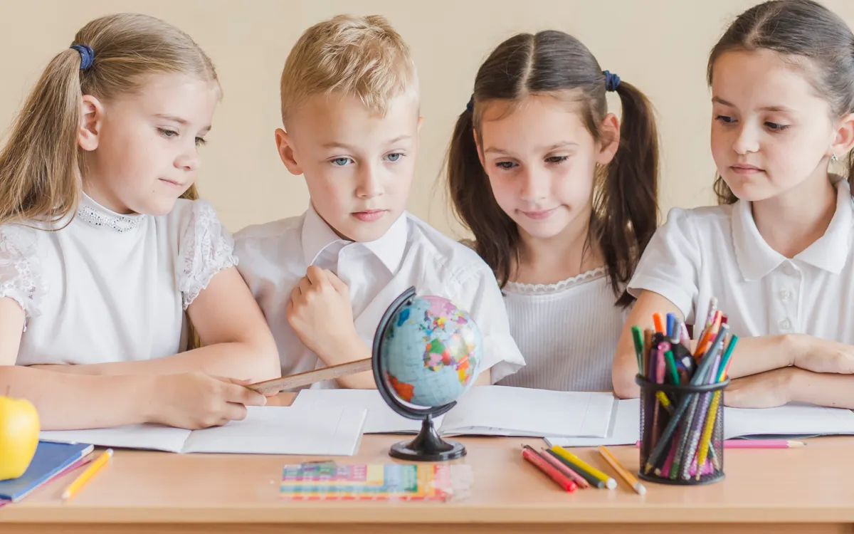 Children sitting around a desk looking at books